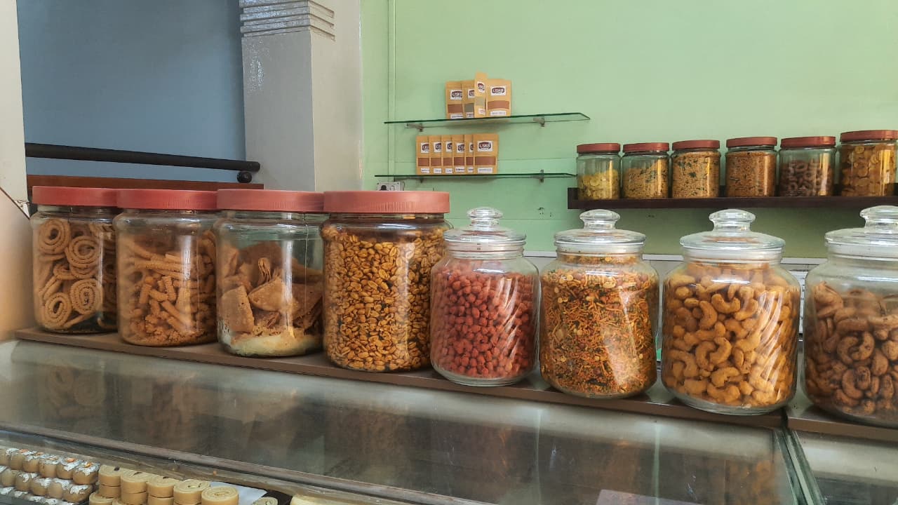 The sweet-and-khara counter to the right of the entrance with each of its fat glass bottles filled to the brim